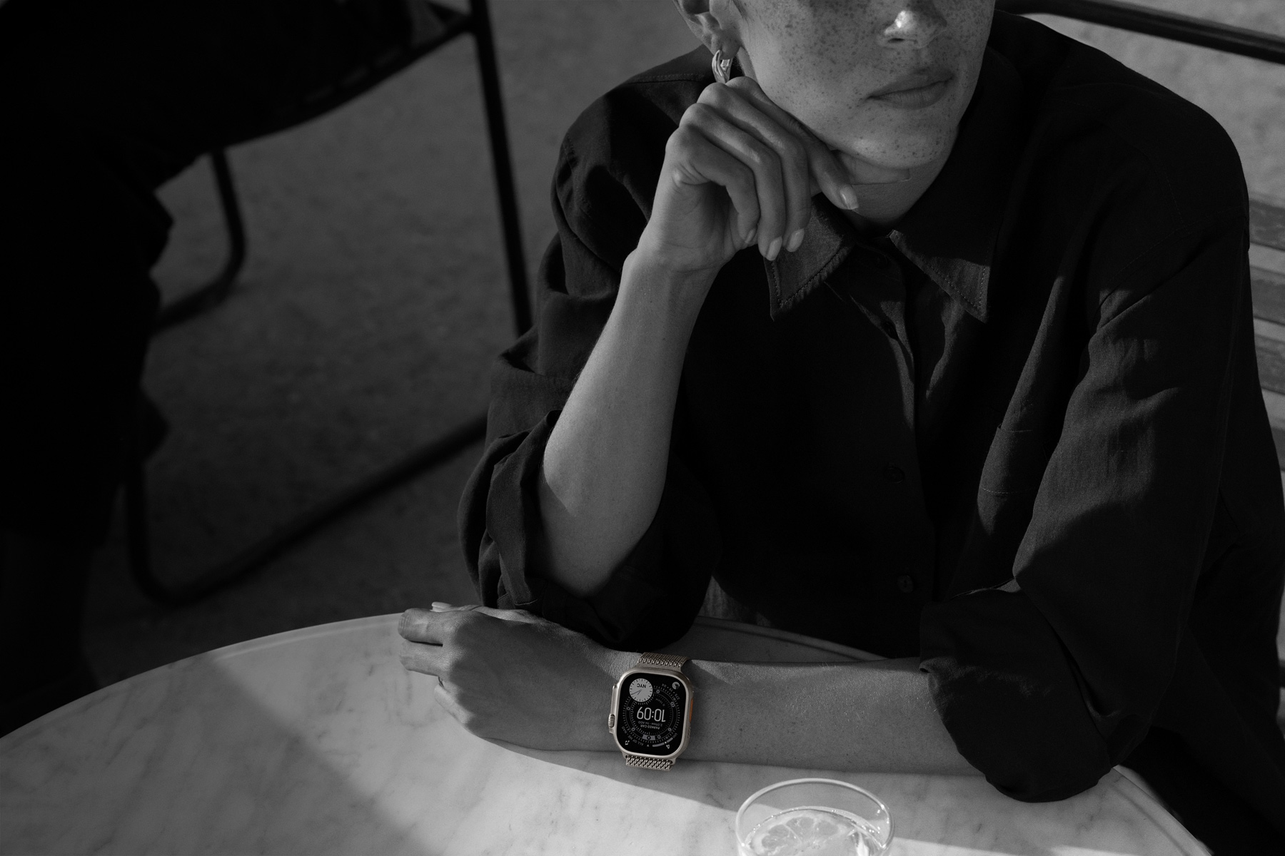 Inimene kannab õhtusöögil olles Apple Watch Ultra 3-e