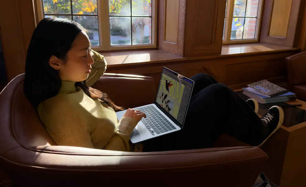一個人坐在椅子上使用 MacBook Air